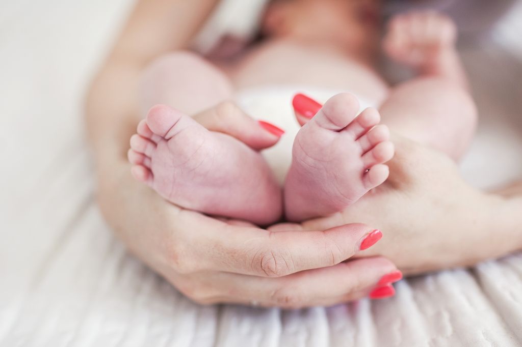 Newborn baby feet in mother's hands