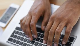 Cropped view of a businessman's hands as he types on his laptop