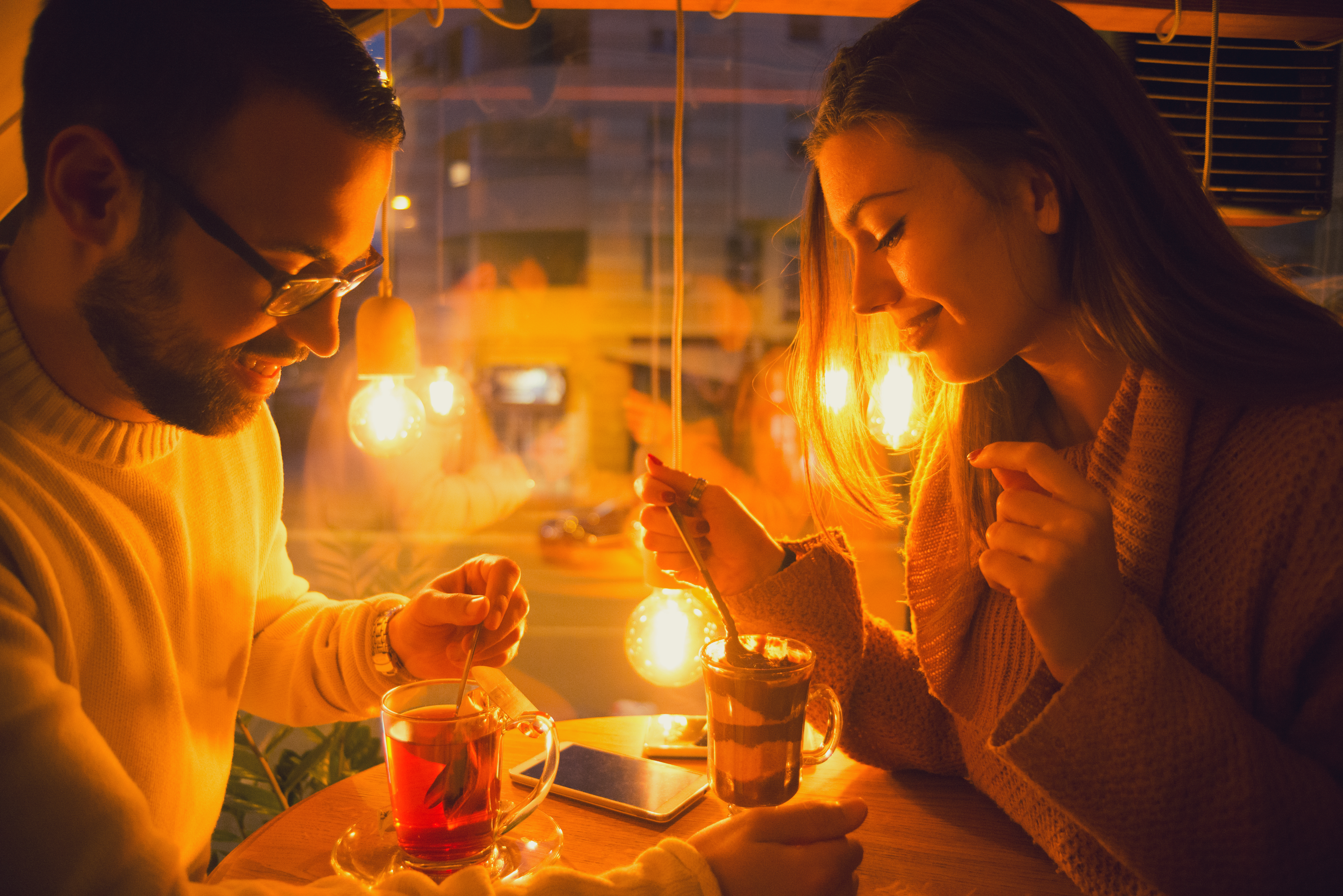 Happy young couple having drinks in the cafe