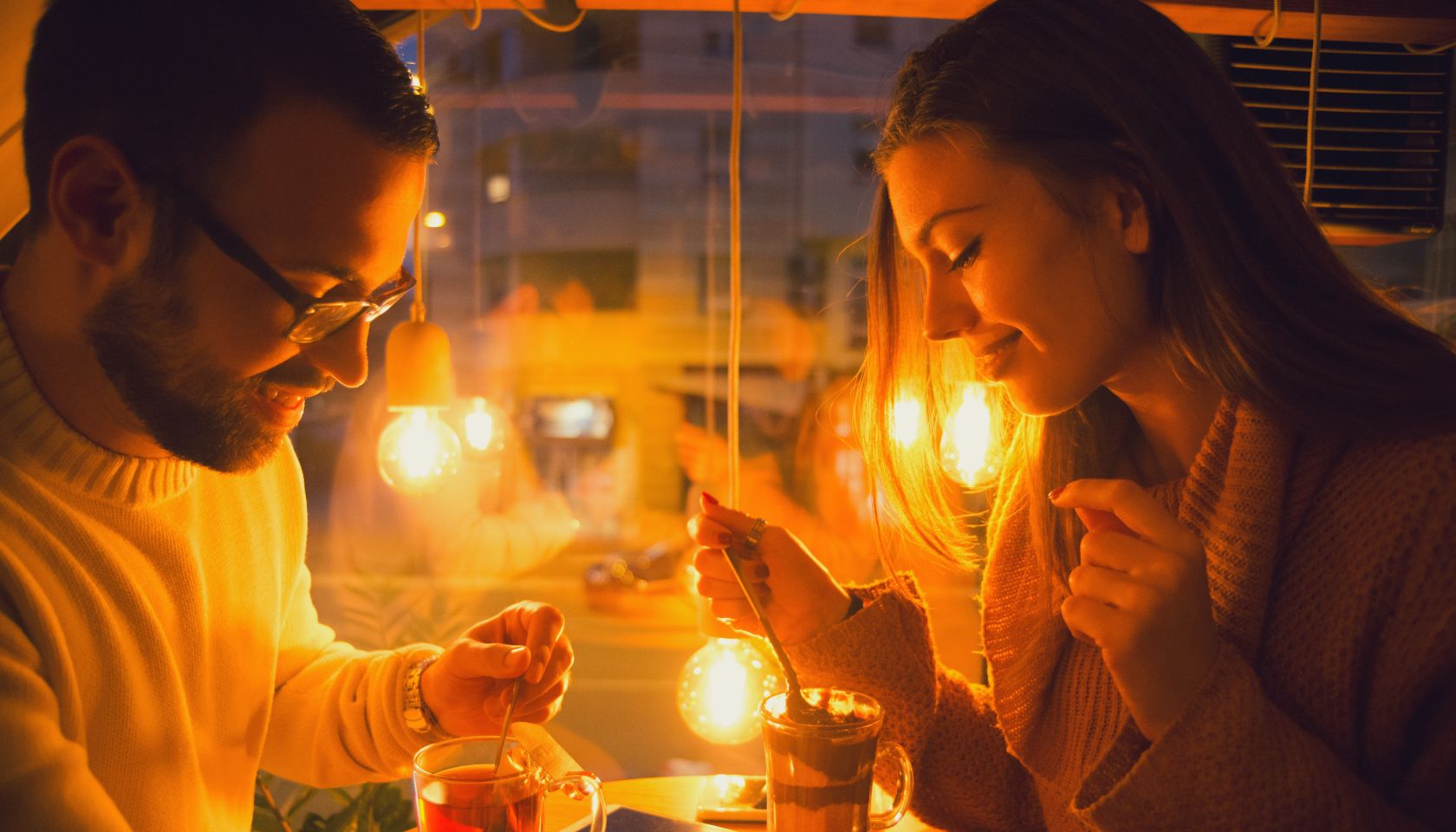 Happy young couple having drinks in the cafe