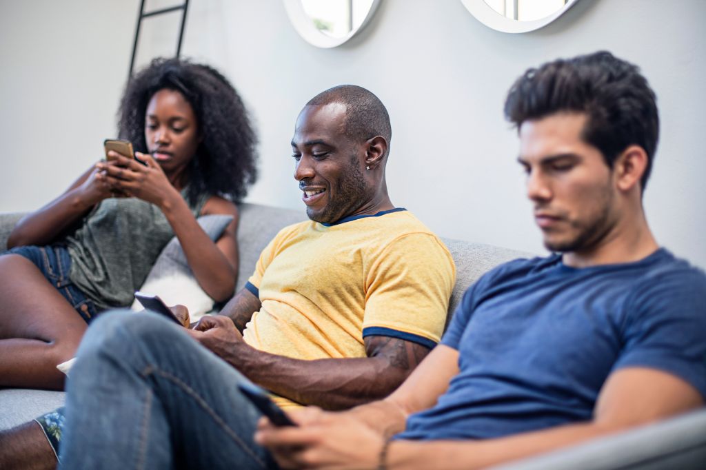 Young friends using smart phones at home