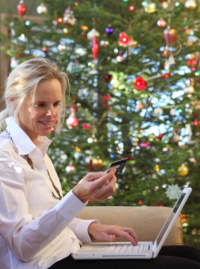 Online Christmas shopping: woman besides xmas tree