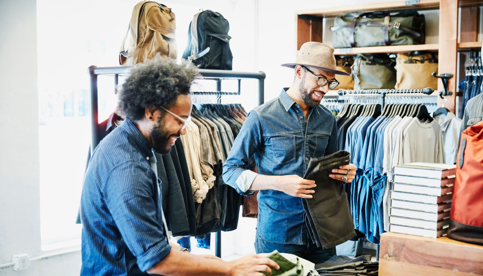 Smiling friends shopping in mens clothing boutique