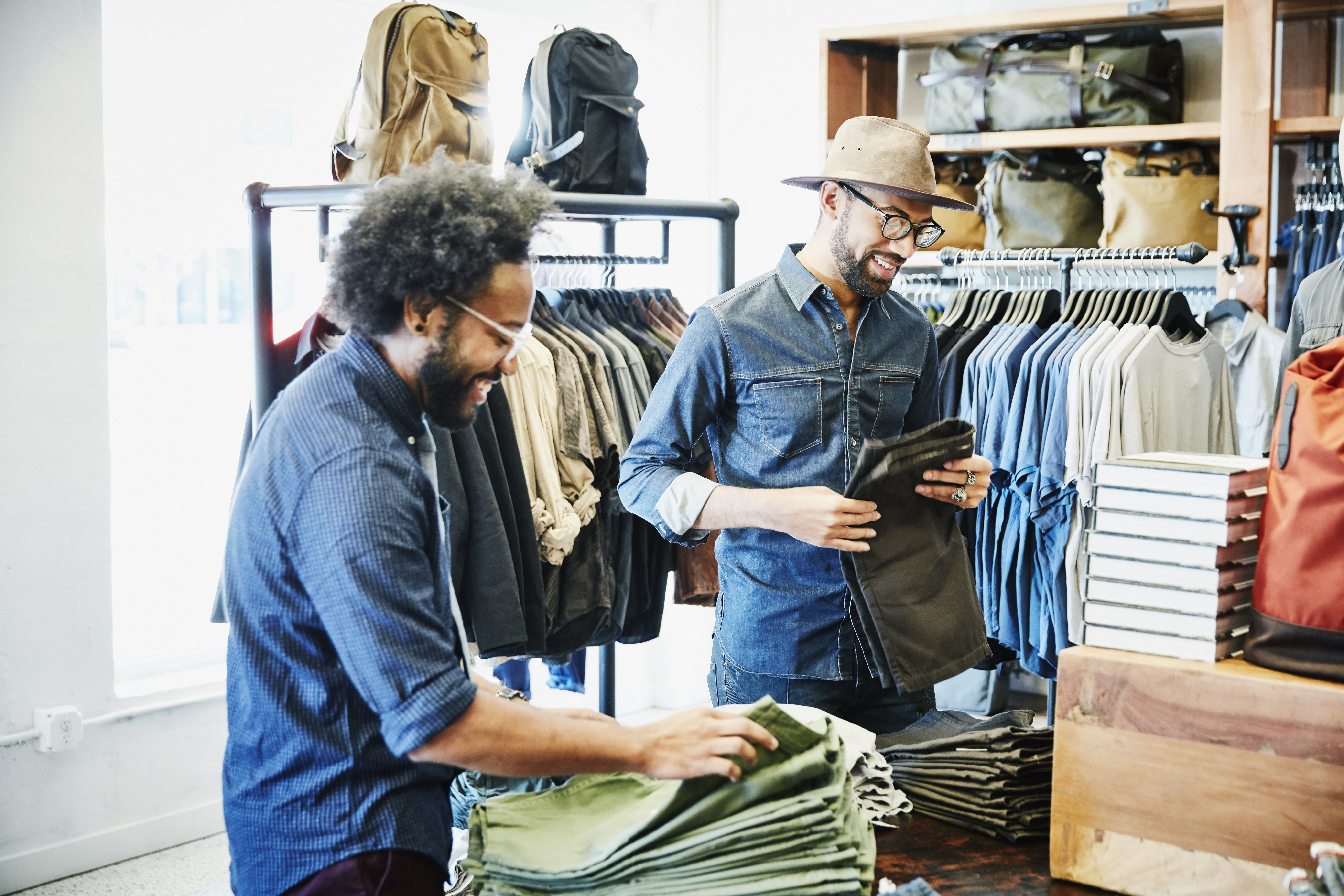 Smiling friends shopping in mens clothing boutique