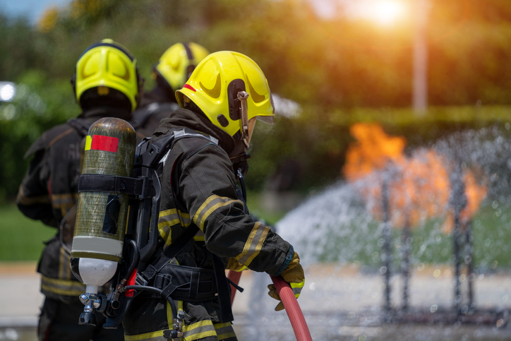 Fireman attacking a fire with water,firefighter team work.