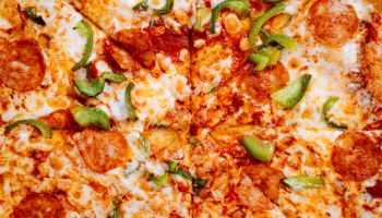 Fresh classic pizza with tomato sauce, mozzarella, spicy chorizo, bell peppers. Food textures top view, close-up