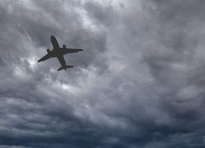 Silhouette of a holiday jet isolated flying under storm clouds