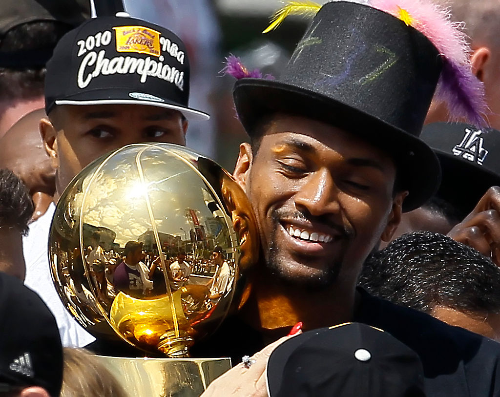 Ron Artest savors a moment with the Larry O'Brien Trophy as he boards a float along with Lakers tea