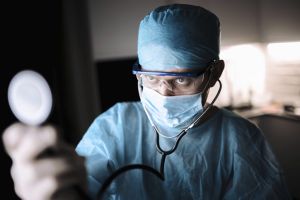 Doctor male surgeon in uniform working with a stethoscope in a medical office