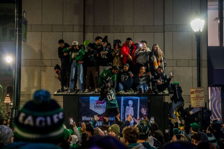 Eagles fans climb on a newsstand
