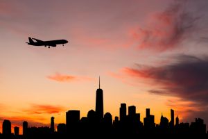 New York cityscape and passenger plane at sunset. USA