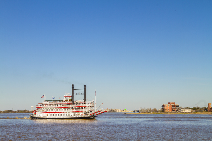 New Orleans, Louisiana in Mardi Gras Carnival Celebrations. Steamboat navigating the Mississippi River near Algiers Point with clear blue sky in New Orleans