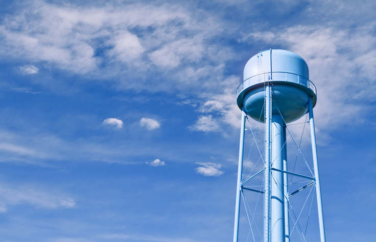Water tower with wispy clouds in sky behind