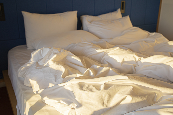 white bedding sheets and pillow in hotel room