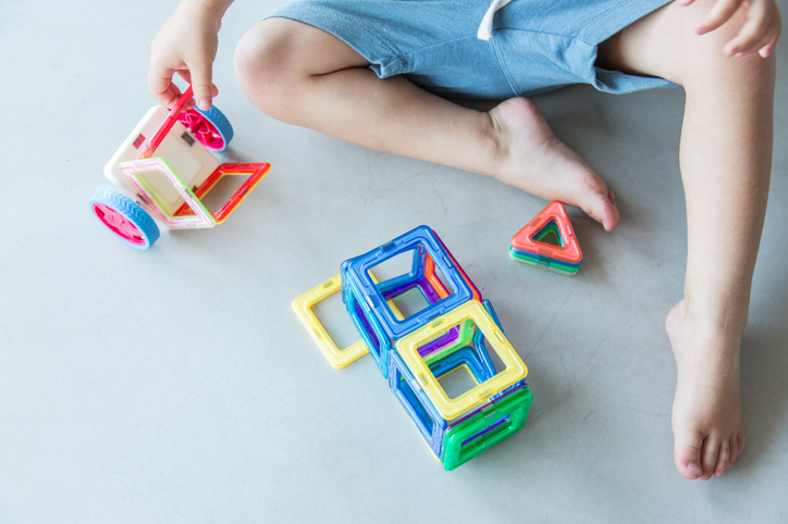 Toddler playing with toy magnets