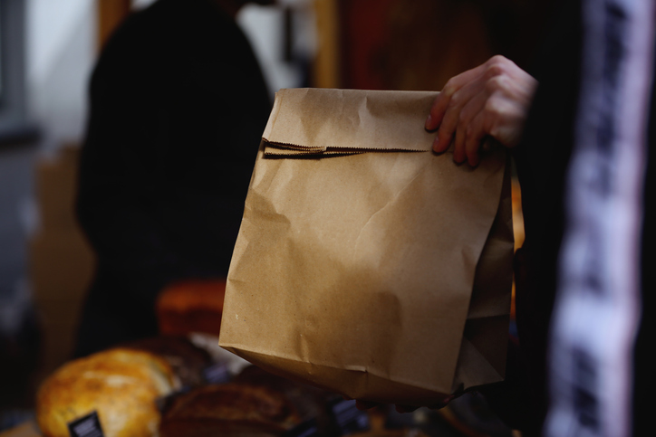 Cropped Customer's Hands Holding Brown Paper Lunch Bag At The Sidewalk Cafeteria