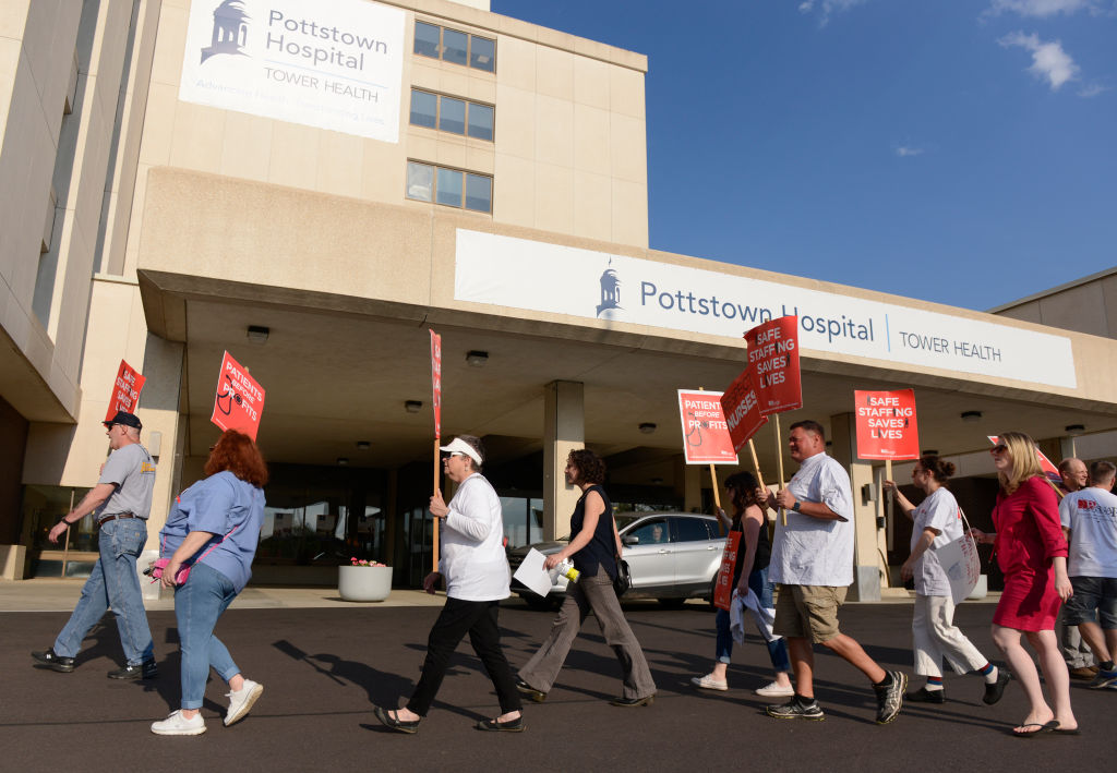 Supporters march past the front door of the hospital. Nurses protest staffing levels and current contract negotiations outside Tower Health's Pottstown Hospital on Tuesday, May 8, 2018. Photo by Jeremy Drey