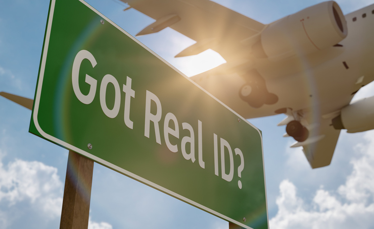 Got Real ID? Green Road Sign with Low Flying Airplane Just Above with Landing Gear Down.