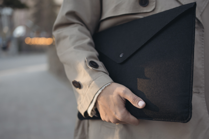 Hand of business woman holding folder with laptop and document outdoors