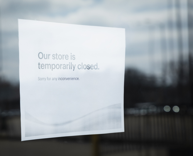 Store closure notice on glass door informs customers about temporary unavailability of services