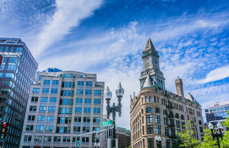 A city street with tall buildings and a clock tower