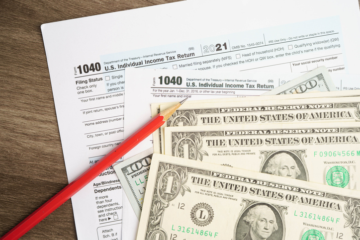 Tax form 1040 U.S. Individual Income Tax Return with dollar banknotes money.
