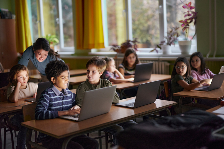 Elementary students e-learning over laptops in the classroom.
