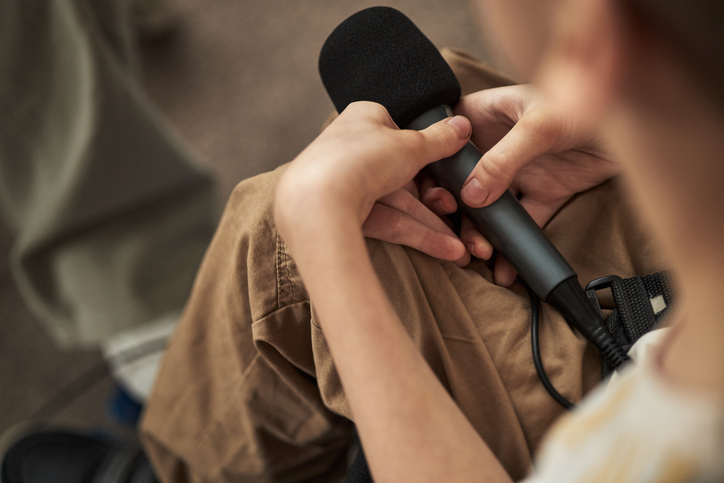 Boy with Disability Holding a Microphone While Speaking at Event