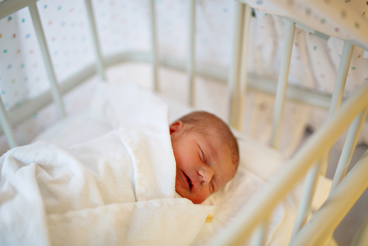 Cute adorable baby girl. sleeping in birth hospital bed. Newborn child three days old laying in bed. Family, new life, childhood, beginning concept