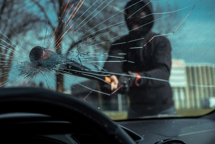 Masked Vandal Breaking Car Window Outdoors