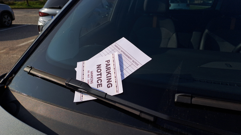 Parking violation notice on car windshield