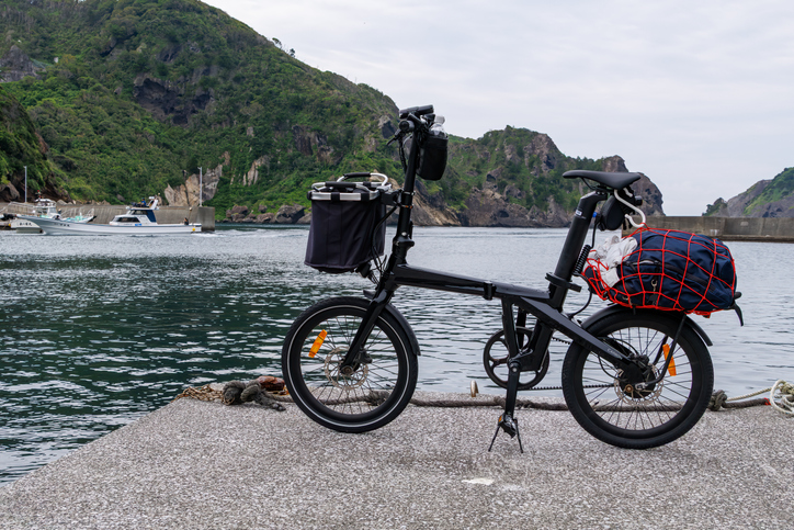 A folding electric bicycle (carbon frame).The scenery of Nakagi Port.Fishing boats are moored in the harbor.