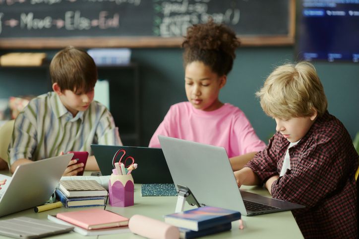 Diverse Schoolchildren Using Laptops in Classroom for Digital Learning
