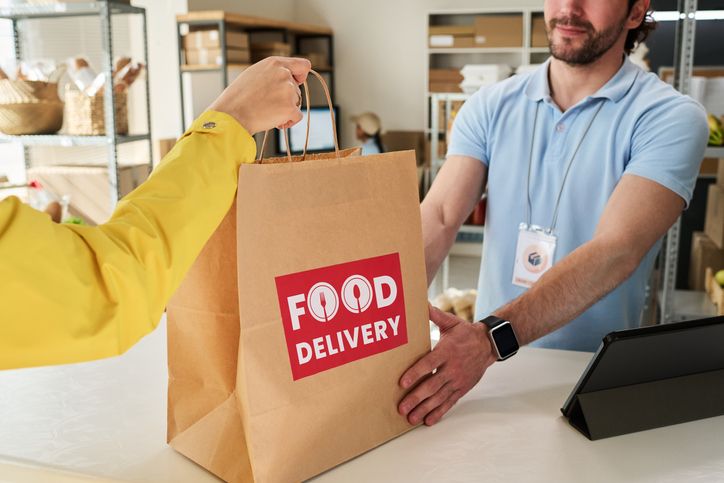 Adult Man Handing over Food Delivery Order at Pickup Point