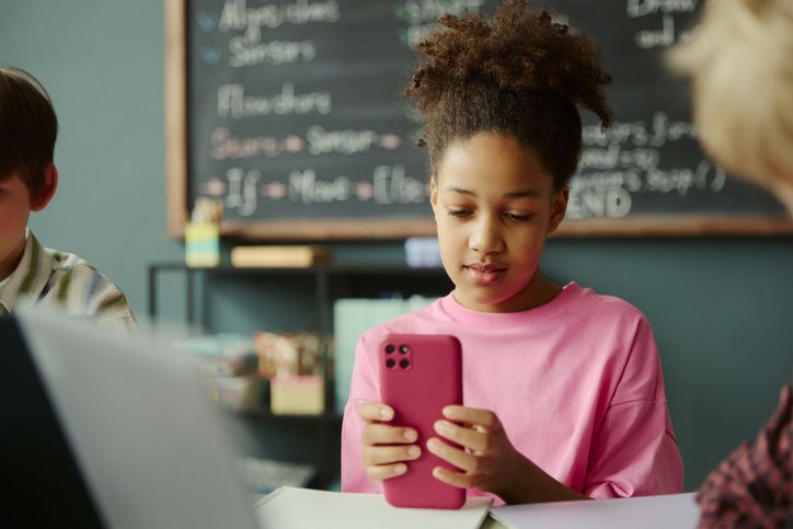 Black Schoolgirl Using Smartphone during Digital Learning in Class